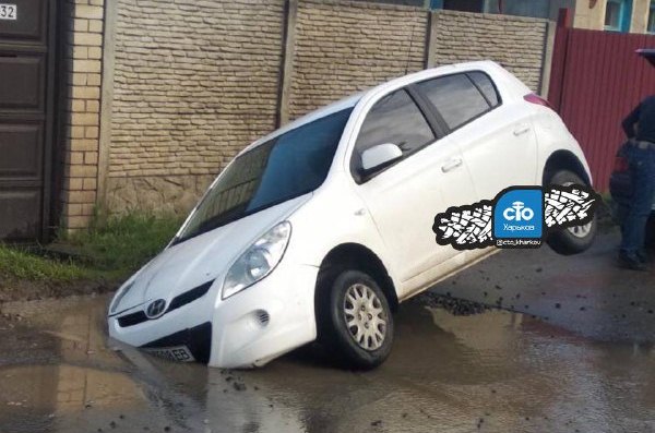 В Харькове машина провалилась в яму под лужей