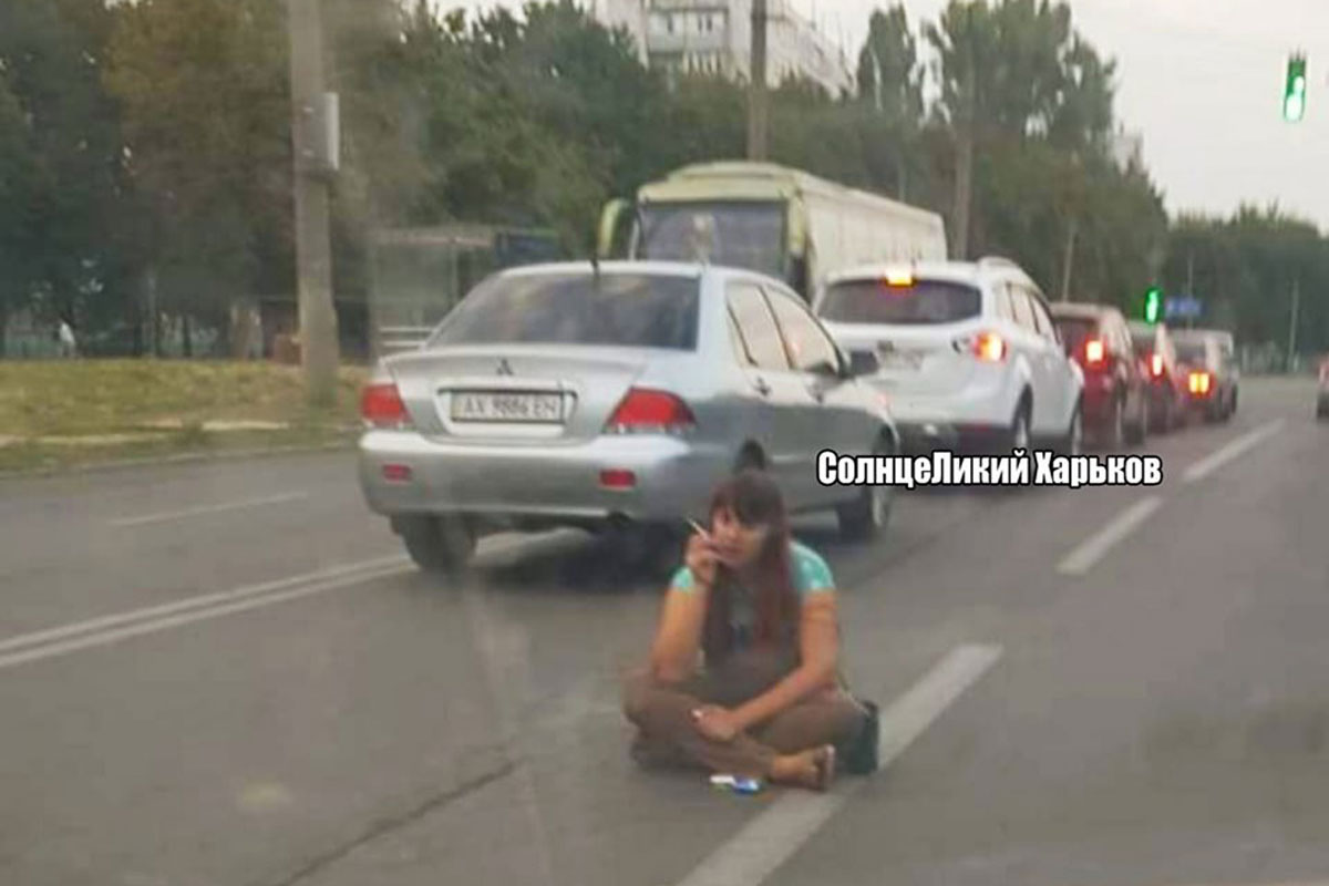 В Харькове женщина уселась посреди проезжей части и закурила (фото, видео)