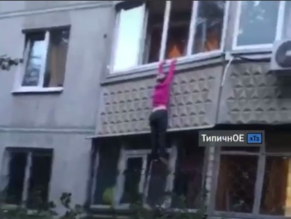 В Харькове женщина повисла на карнизе балкона (видео)