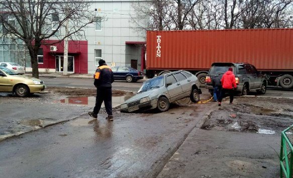 В Харькове машина застряла в огромной яме